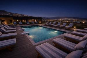 a swimming pool with chaise lounges and lounge chairs at Taghazout Palm Hotel in Taghazout