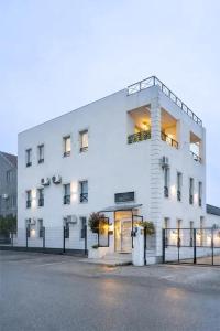 a large white building with lights on at MiniCity Inn in Belgrade