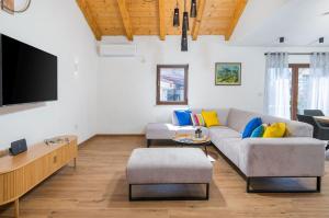 a living room with a couch and a flat screen tv at Villa STOCK 66 by Villsy in Štokovci