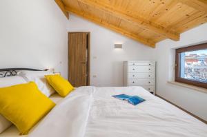 a bedroom with a large white bed with yellow pillows at Villa STOCK 66 by Villsy in Štokovci +25 photos
