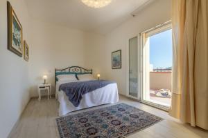 a bedroom with a bed and a large window at Elafi Penthouse in Cagliari