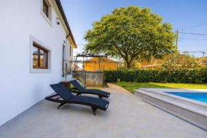 two black chairs sitting on a patio next to a pool at Villa STOCK 66 by Villsy in Štokovci