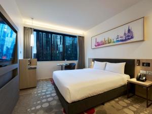 a hotel room with a bed and a television at ibis Melbourne Central in Melbourne