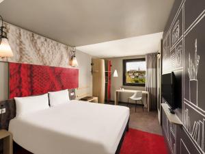 a hotel room with a white bed and a desk at ibis Budapest Castle Hill in Budapest