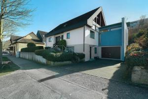 a white house with a black roof and a driveway at Ferienwohnung Ettenheim in Ettenheim
