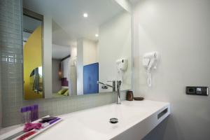 a bathroom with a sink and a mirror at The Purple Hotel - Adults Only in San Antonio