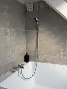 Eine Dusche in einem Badezimmer mit einer schwarzen Flasche auf dem Waschbecken in der Unterkunft Leonard in Landerneau