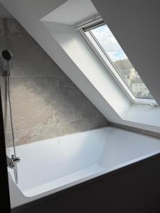 ein Badezimmer mit Fenster und einem weißen Regal in der Unterkunft Leonard in Landerneau + 3 Fotos