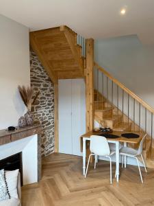 ein Zimmer mit Tisch und Stühlen und einer Treppe in der Unterkunft Leonard in Landerneau