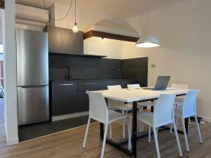a kitchen with a table with chairs and a laptop on it at Art Residency Borgo Castello in Gorizia
