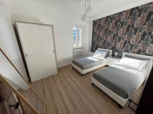 a bedroom with two beds and a mirror at Art Residency Borgo Castello in Gorizia