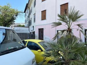 a yellow car parked next to a pink and white building at Art Residency Borgo Castello in Gorizia