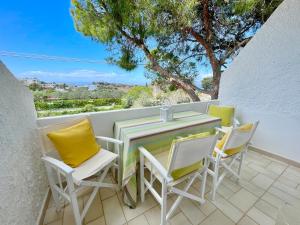 a table and chairs on a balcony with a view at FLY, Oneiropagida, Aegina in Vathí