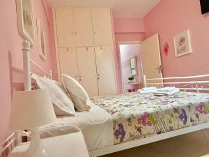 a bedroom with a bed in a pink room at FLY, Oneiropagida, Aegina in Vathí