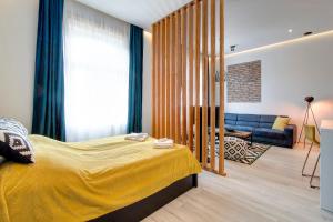 1 dormitorio con cama amarilla y sofá en Luxury Apartment by Hi5 -Andrássy Suite, en Budapest