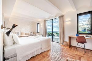 a bedroom with a bed and a desk and a window at Casa del Capitan in Cadaqués