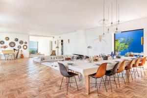 a dining room and living room with a long table and chairs at Casa del Capitan in Cadaqués +15 photos