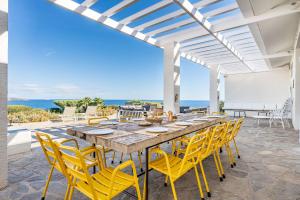 a dining room with a table and yellow chairs at Casa del Capitan in Cadaqués