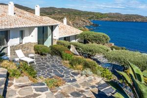 a house with a stone walkway next to the ocean at Casa del Capitan in Cadaqués