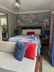 a bedroom with a bed and a couch and a brick wall at Ocean gate in Hartbeespoort +1 photo
