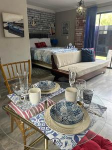 a living room with two tables with plates and glasses at Ocean gate in Hartbeespoort