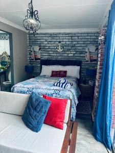 a bedroom with a bed and a couch with pillows at Ocean gate in Hartbeespoort