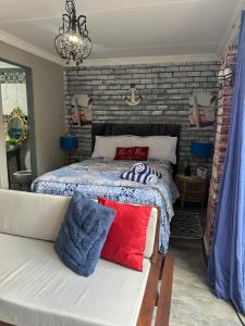 a bedroom with a bed and a brick wall at Ocean gate in Hartbeespoort