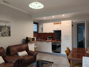 a living room with a couch and a kitchen at La maison de l'Usine in Tartas