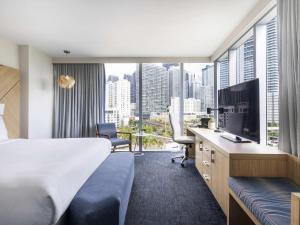 a hotel room with a bed desk and a large window at Novotel Miami Brickell in Miami