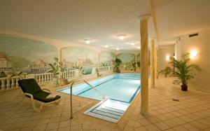 a swimming pool in a room with a painting on the wall at Hotel-Restaurant Walserhof in Wasserburg