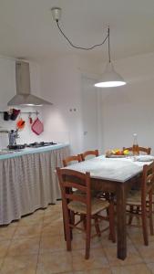 y cocina con mesa, sillas y fogones. en Dolce Casa, en Vezzano Ligure