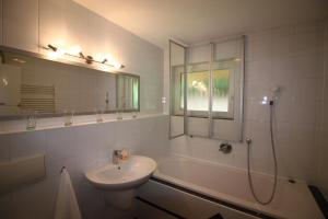 ein weißes Bad mit einem Waschbecken und einer Dusche in der Unterkunft CasaLuna in Fürth