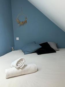 a bed with a white towel on top of it at Léonie-Les appart's de Léon in Landerneau