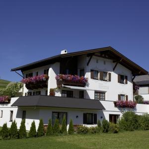 un edificio blanco con cajas de flores. en Haus Kaschutnig, en Fiss