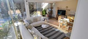 a living room with white couches and a television at Casa El Castañal con Piscina Privada in Vigo