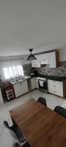 a kitchen with a wooden table and chairs at Dafnonas House - Bright & Modern in Leonidio