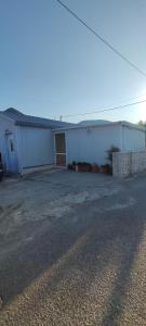 a large white building with a garage at Dafnonas House - Bright & Modern in Leonidio