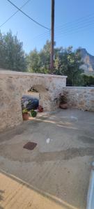 a stone wall with potted plants in a yard at Dafnonas House - Bright & Modern in Leonidio