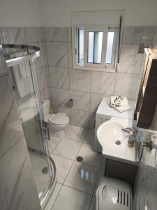 a white bathroom with a sink and a toilet at Dafnonas House - Bright & Modern in Leonidio