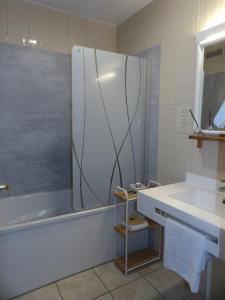 a bathroom with a shower and a sink and a tub at Logis Hotel Restaurant Le Jardin Délice in Saint-Victor +19 photos