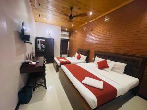 a hotel room with two beds and a desk and a television at J Hotel in Jaffna