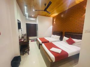 a hotel room with two beds and a desk at J Hotel in Jaffna