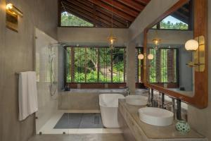 a bathroom with two sinks and a tub and a mirror at Ishq Digana in Digana