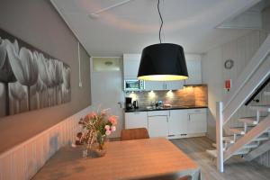 a kitchen and dining room with a table and a black light at Woeste Hoeve 114 in Biggekerke +13 photos
