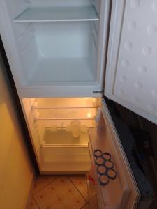 an empty refrigerator with its door open in a kitchen at TN Apartments Adina in Diani Beach