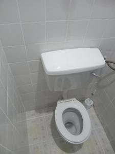 a bathroom with a white toilet in a stall at TN Apartments Adina in Diani Beach +8 photos