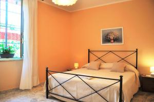 サンタレッシオ・シークロにあるAl Vico dei Limoniのベッドルーム1室(オレンジ色の壁のベッド1台付)