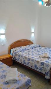 a bedroom with two beds and two tables and lights at Maras in Palinuro