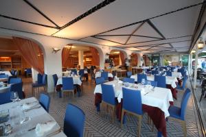 a restaurant with white tables and blue chairs at Hotel Gabbiano in San Domino