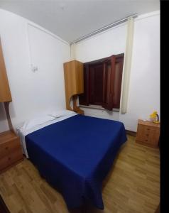 a bedroom with a blue bed and a window at Maras in Palinuro